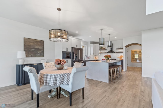 dining room with sink and light wood-type flooring