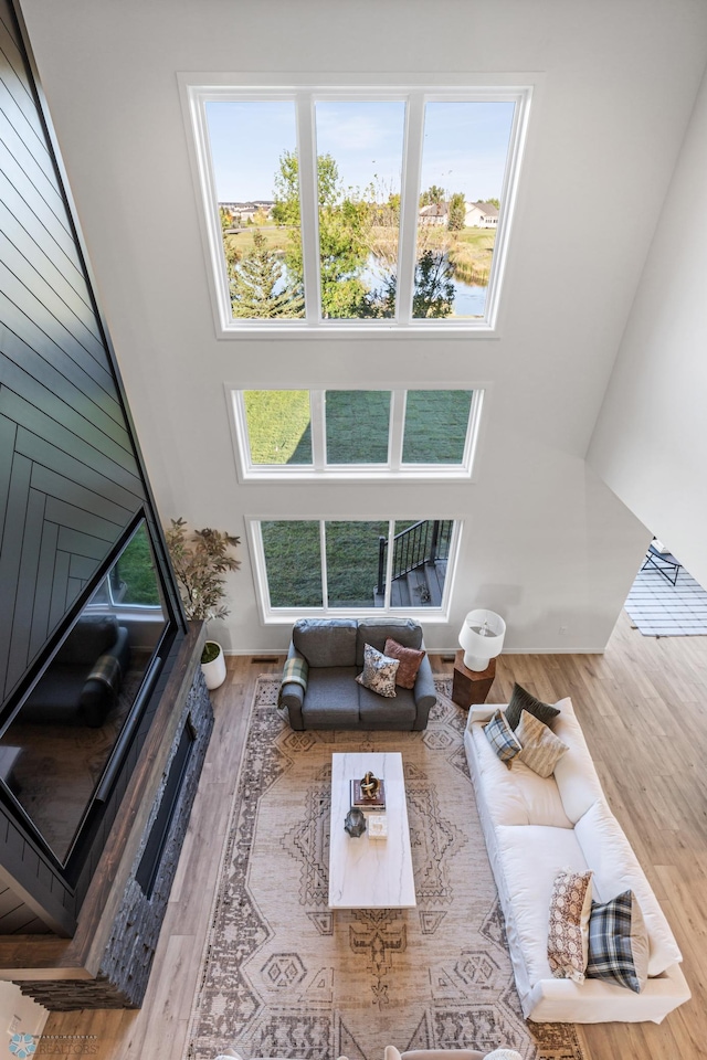 living room with wood-type flooring and a towering ceiling