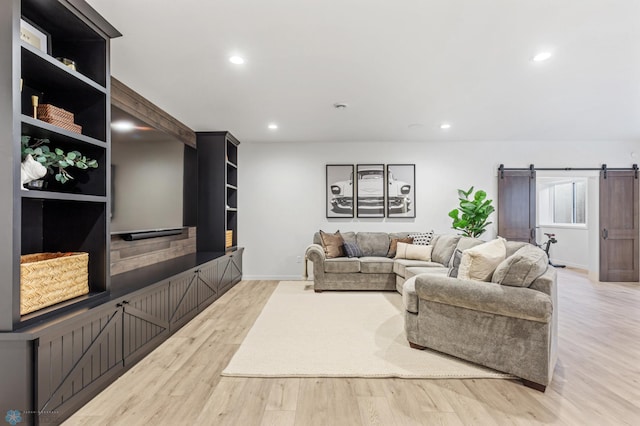 living room featuring a barn door and light hardwood / wood-style floors