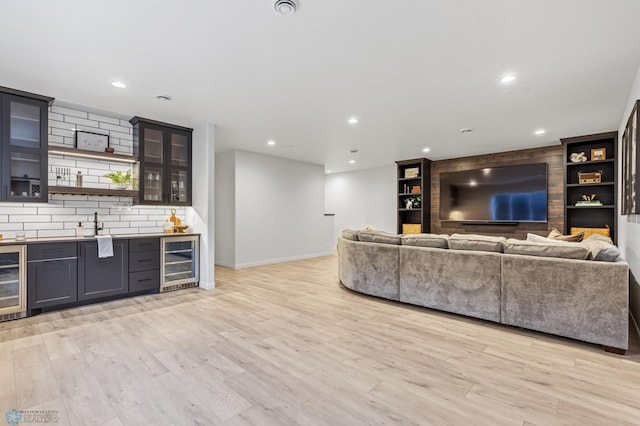 living room featuring bar, beverage cooler, and light hardwood / wood-style flooring