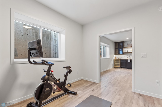 exercise area with sink and hardwood / wood-style floors