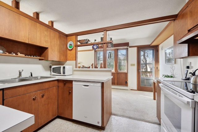 kitchen featuring kitchen peninsula, a textured ceiling, white appliances, a baseboard heating unit, and sink