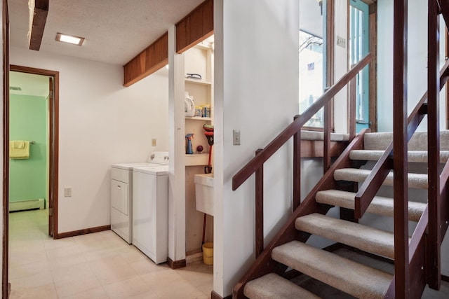 staircase with a textured ceiling, separate washer and dryer, and baseboard heating