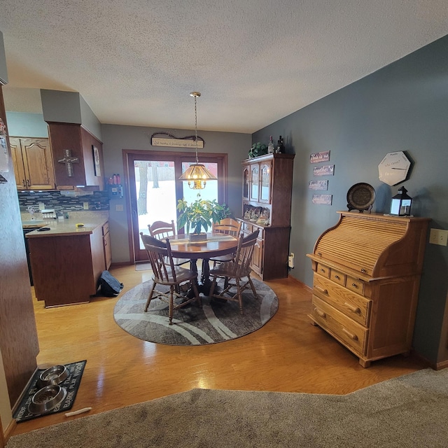 dining area featuring a textured ceiling and light hardwood / wood-style floors