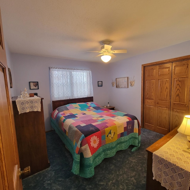 bedroom with a ceiling fan, a closet, dark carpet, and a textured ceiling