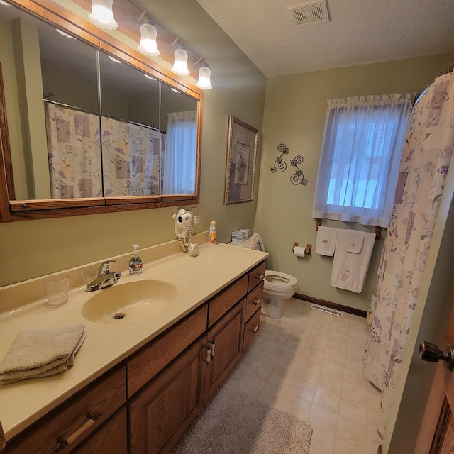 full bathroom with toilet, baseboards, visible vents, and vanity