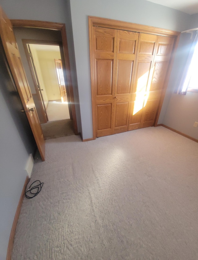 unfurnished bedroom with light carpet and baseboards