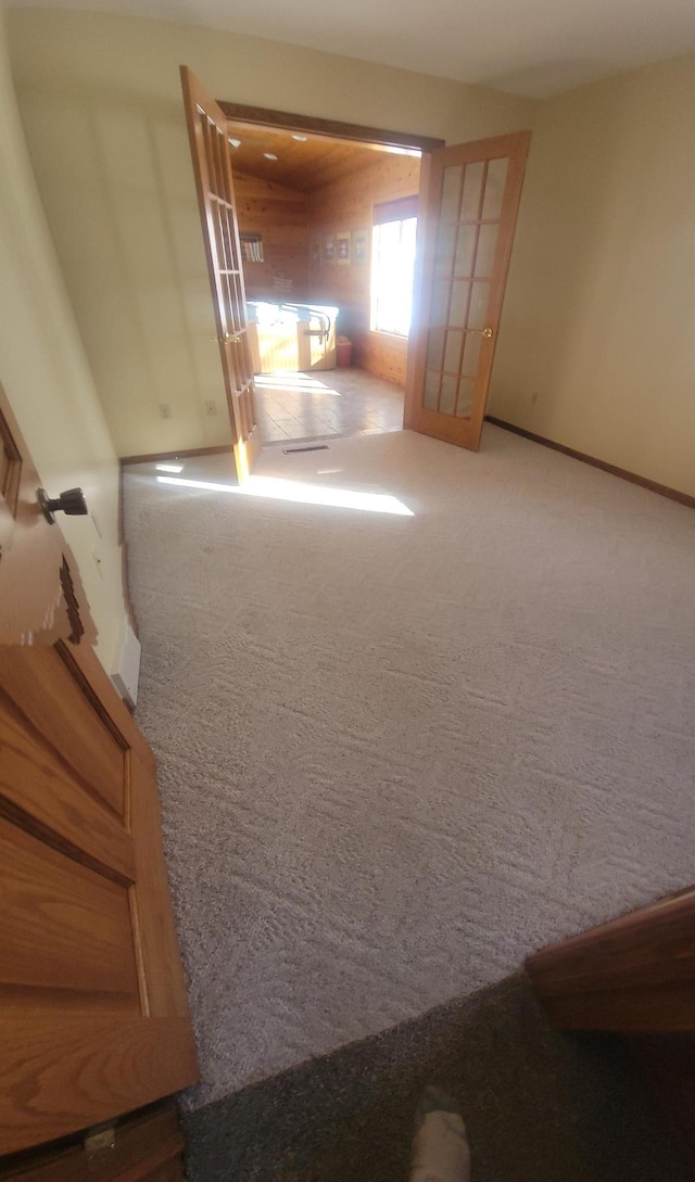 spare room featuring carpet and baseboards