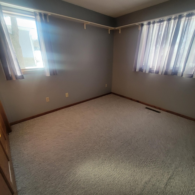 carpeted empty room with baseboards and visible vents