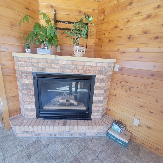 room details featuring a brick fireplace and wooden walls