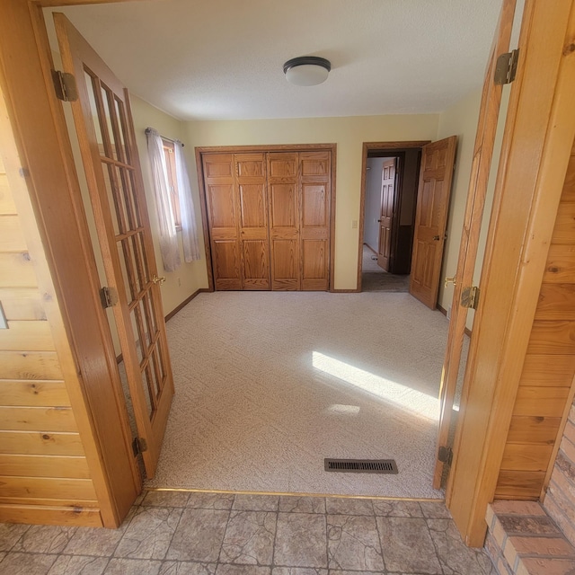 hall featuring carpet floors and visible vents