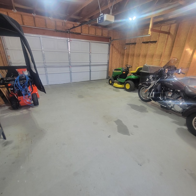 garage featuring wooden walls and a garage door opener