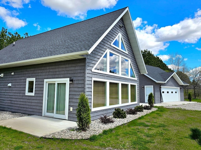 back of house featuring a yard and a garage