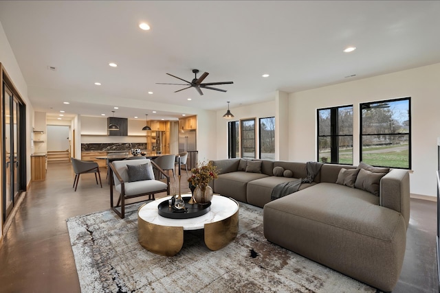 living room featuring a ceiling fan, finished concrete flooring, and recessed lighting