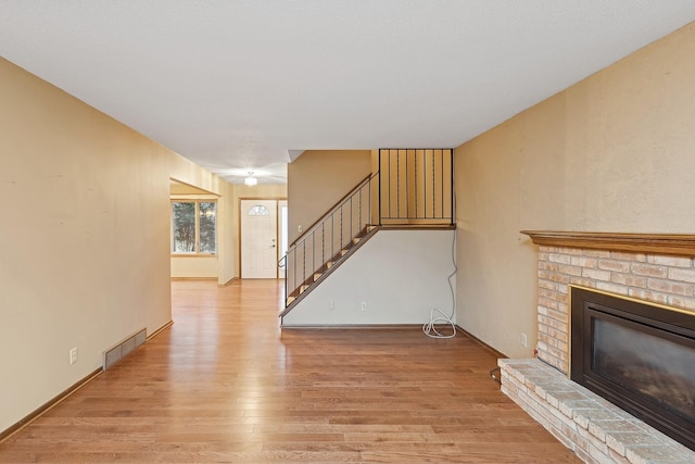 unfurnished living room featuring a fireplace and light wood-type flooring