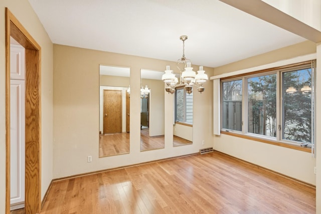 unfurnished dining area featuring a chandelier and hardwood / wood-style flooring