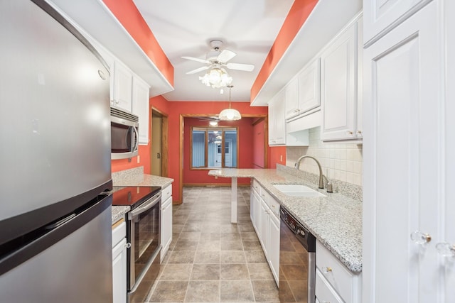 kitchen featuring sink, white cabinets, decorative light fixtures, and appliances with stainless steel finishes