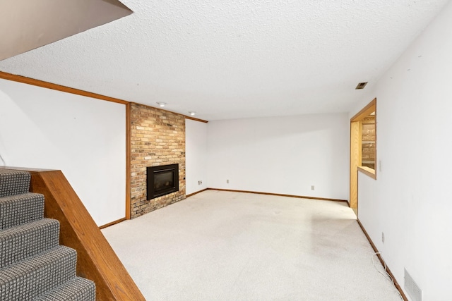 unfurnished living room featuring light carpet, a textured ceiling, and a brick fireplace