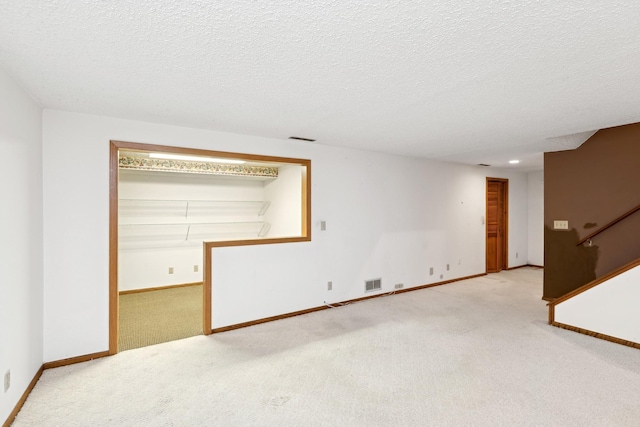 carpeted spare room featuring a textured ceiling