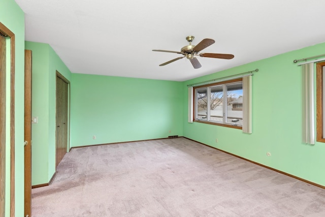 carpeted spare room featuring ceiling fan