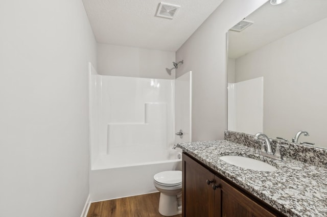 full bath featuring toilet, wood finished floors, vanity, visible vents, and shower / bathing tub combination