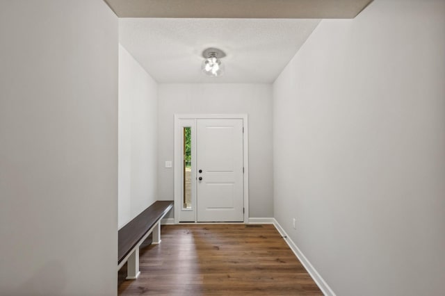 entryway featuring dark wood finished floors, a textured ceiling, and baseboards