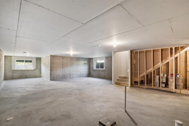 basement with a healthy amount of sunlight and stairway