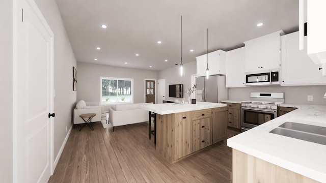 kitchen with a kitchen island, decorative light fixtures, white cabinetry, stainless steel fridge, and stove