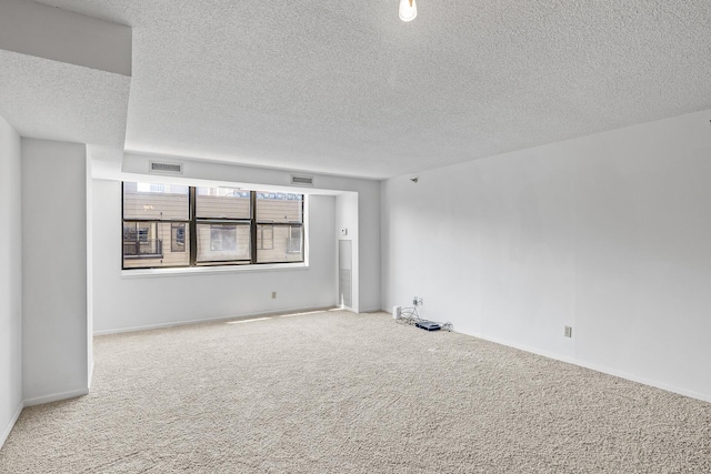 unfurnished room with a textured ceiling and carpet floors