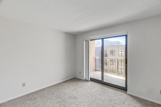 carpeted empty room with a textured ceiling