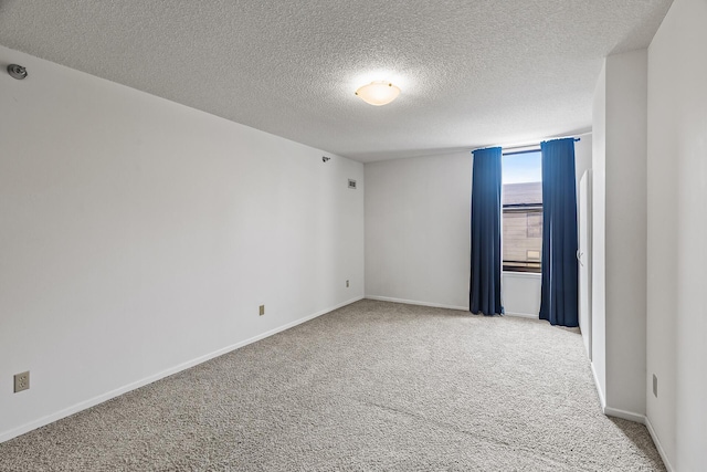 carpeted empty room with a textured ceiling