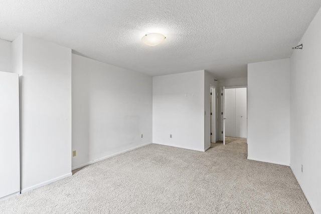 carpeted spare room featuring a textured ceiling