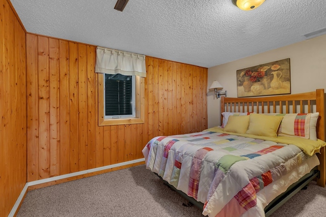 carpeted bedroom with visible vents and wooden walls