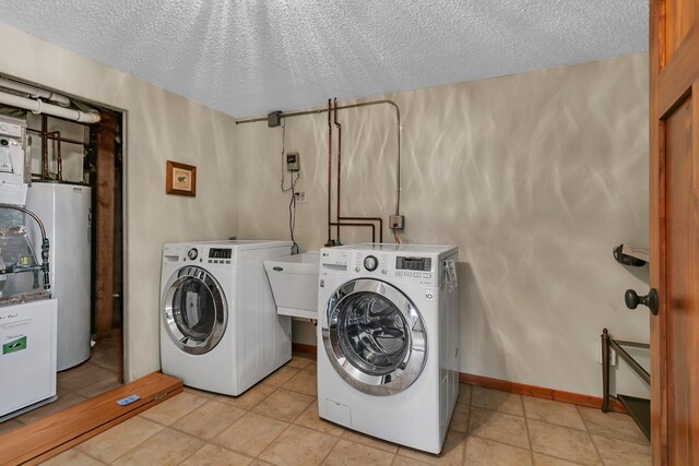 laundry room featuring gas water heater, a textured ceiling, independent washer and dryer, and laundry area