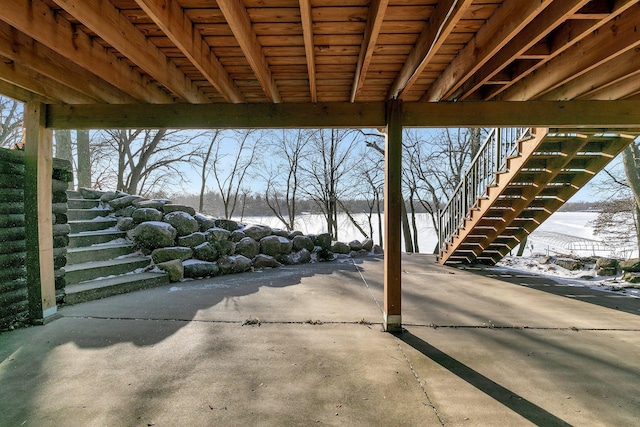 view of patio with stairway and a water view