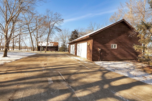 view of property exterior featuring an outbuilding, concrete driveway, and a garage