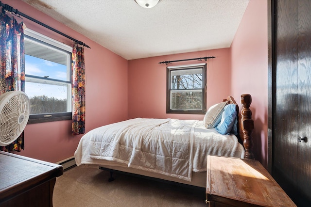 carpeted bedroom featuring a baseboard radiator and a textured ceiling