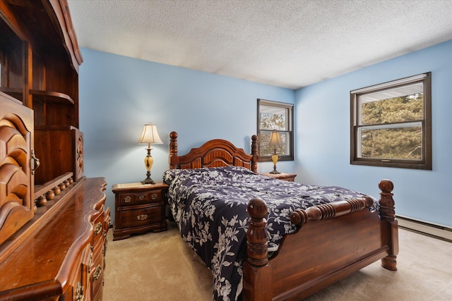 carpeted bedroom with baseboard heating and a textured ceiling