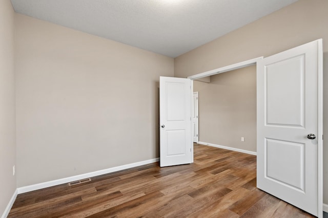 unfurnished bedroom featuring a textured ceiling and hardwood / wood-style flooring