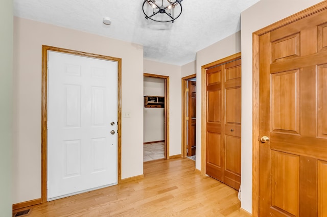 hallway featuring a textured ceiling and light hardwood / wood-style floors