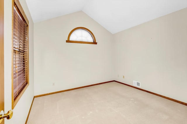 unfurnished room with carpet and vaulted ceiling