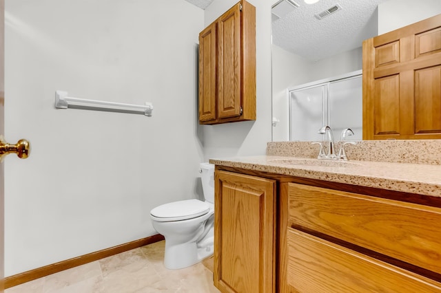 bathroom featuring vanity, a textured ceiling, toilet, and a shower with door