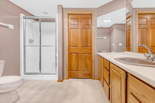 bathroom with tile patterned flooring, vanity, toilet, and an enclosed shower