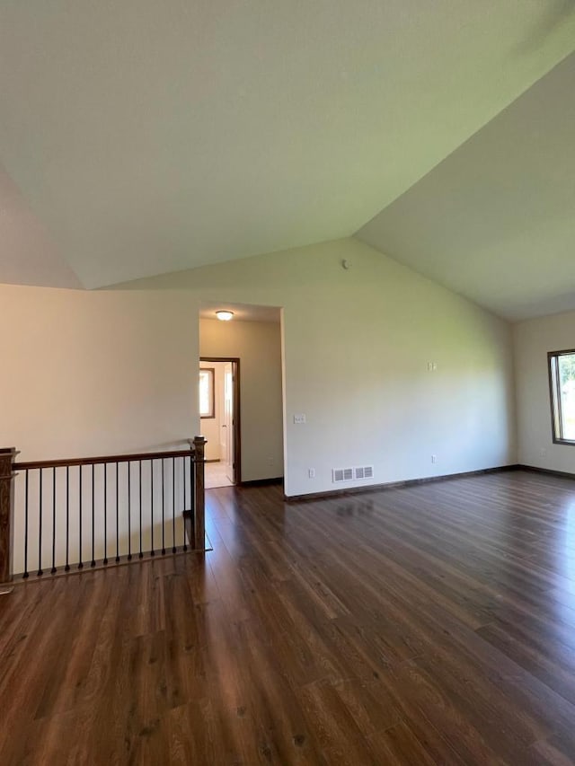 unfurnished room with lofted ceiling and dark wood-type flooring