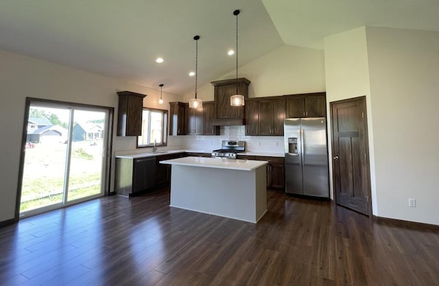 kitchen featuring a center island, decorative light fixtures, a healthy amount of sunlight, and appliances with stainless steel finishes