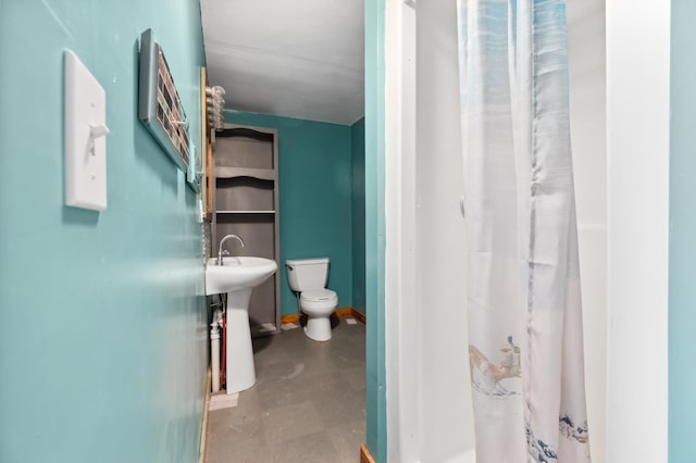 bathroom with concrete flooring and toilet