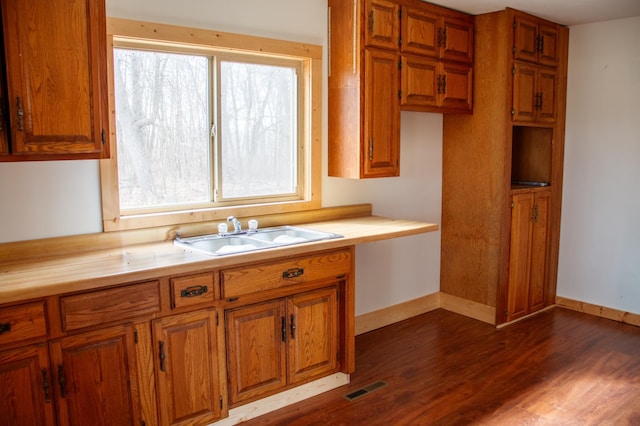 61684 260th St, Hewitt, MN 56453 - kitchen with a sink, dark wood finished floors, visible vents, brown cabinets, and light countertops