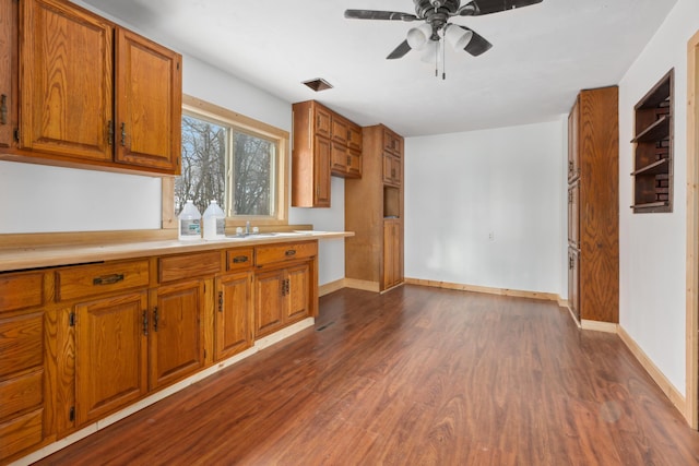 61684 260th St, Hewitt, MN 56453 - kitchen featuring dark wood finished floors, light countertops, a ceiling fan, baseboards, and brown cabinetry