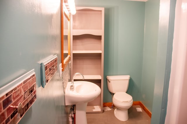 61684 260th St, Hewitt, MN 56453 - bathroom featuring toilet, baseboards, and a sink