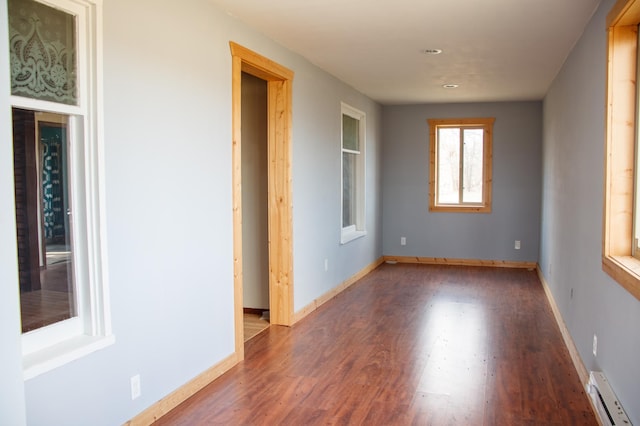61684 260th St, Hewitt, MN 56453 - unfurnished room featuring baseboard heating, baseboards, and wood finished floors